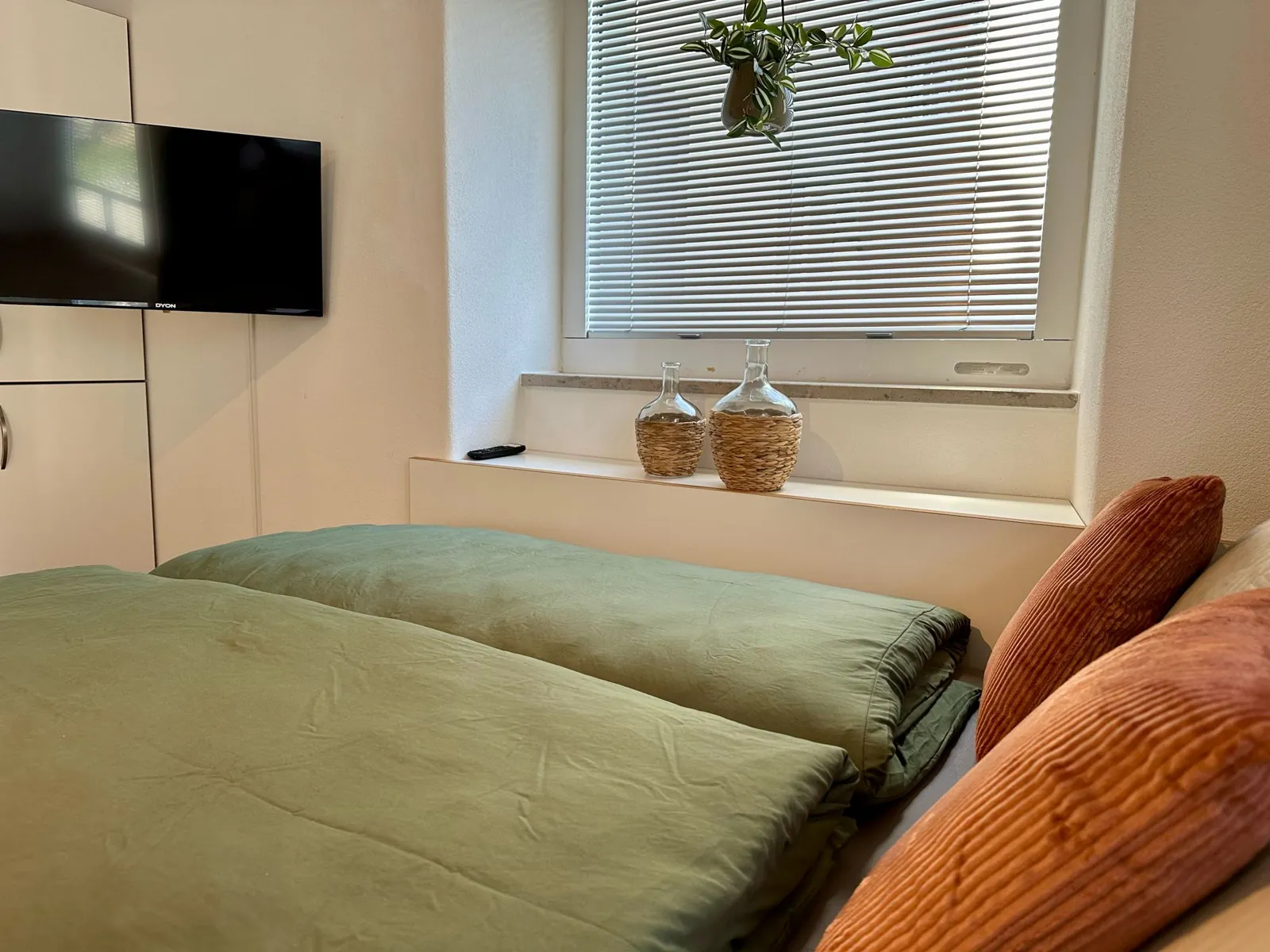 Ferienwohnung Lieblingsort – Bett mit Fenster und Flachbild-TV